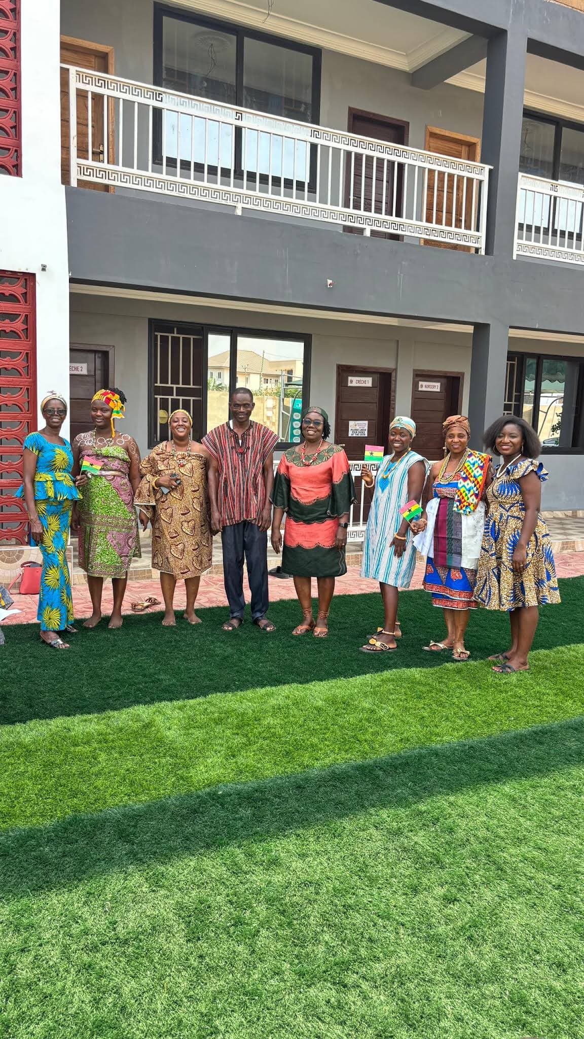 Members of the ALLSWELL Premier School community wearing cultural dress outside the school building
