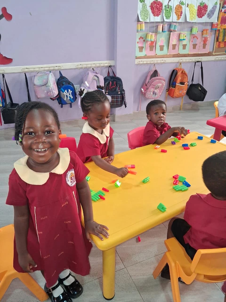 Young ALLSWELL Premier School learners exploring colourful building pieces around a classroom table